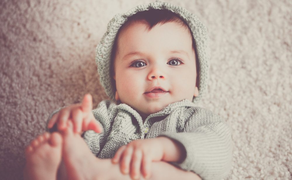Baby Junge in grauer Jacke