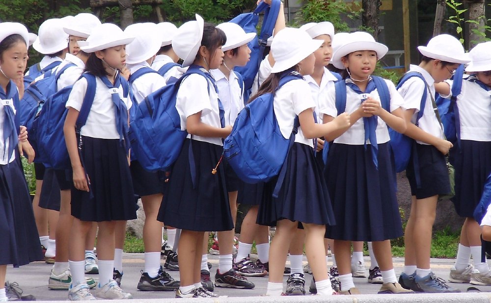 Kinder in Japan in Schuluniform warten auf den Bus